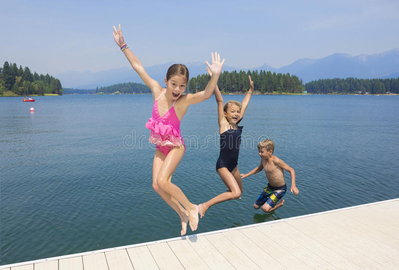 kids playing lake their summer vacation enjoying together jumping off dock crystal blue waters