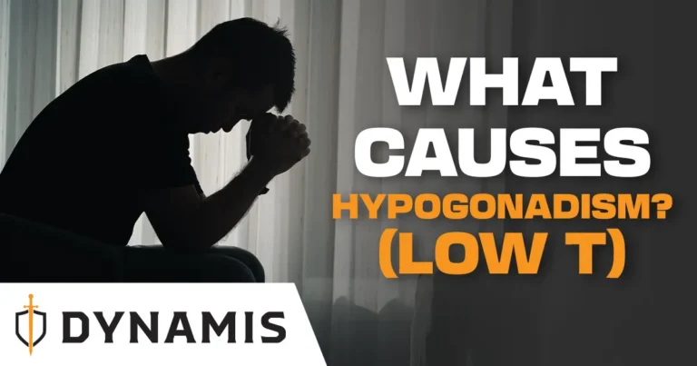 A man sits hunched in dim light with his head in his hands; text reads "What Causes Hypogonadism? (Low T), Dynamis"